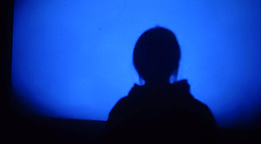 Blue projected film and visitor silhouette